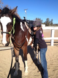 Pulling down on the stirrup.