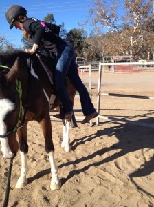 Standing in the stirrups.